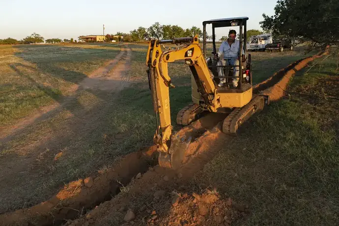 Mini excavator trenching for sewer line